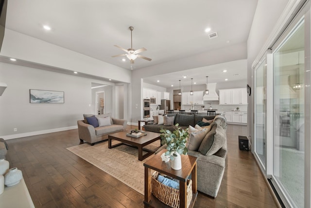 living room with dark hardwood / wood-style flooring and ceiling fan