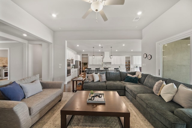 living room featuring wood-type flooring and ceiling fan