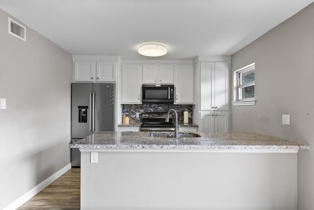 kitchen featuring sink, light stone counters, tasteful backsplash, stainless steel appliances, and white cabinets