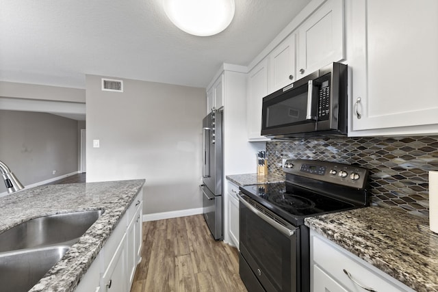 kitchen with sink, white cabinetry, light hardwood / wood-style floors, black range with electric cooktop, and high end refrigerator