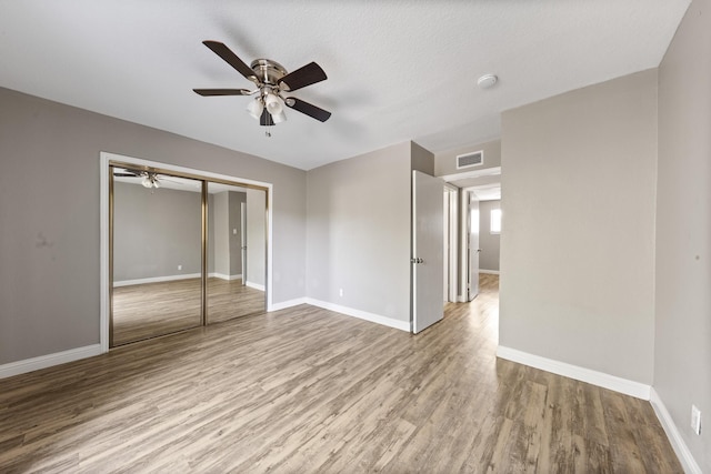 unfurnished bedroom with ceiling fan, a closet, and light hardwood / wood-style flooring