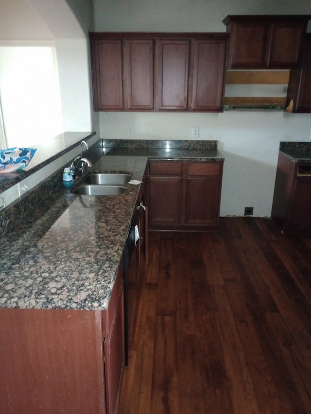 kitchen featuring sink, dark stone countertops, and dark hardwood / wood-style floors