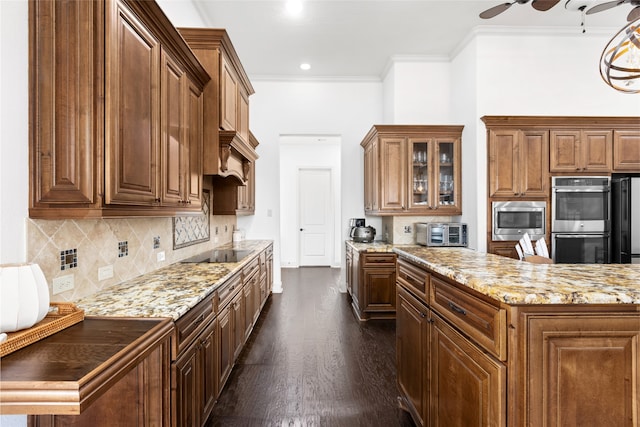 kitchen featuring stainless steel appliances, light stone counters, ornamental molding, dark hardwood / wood-style flooring, and decorative backsplash