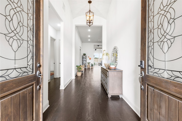 entryway with a notable chandelier and dark hardwood / wood-style floors