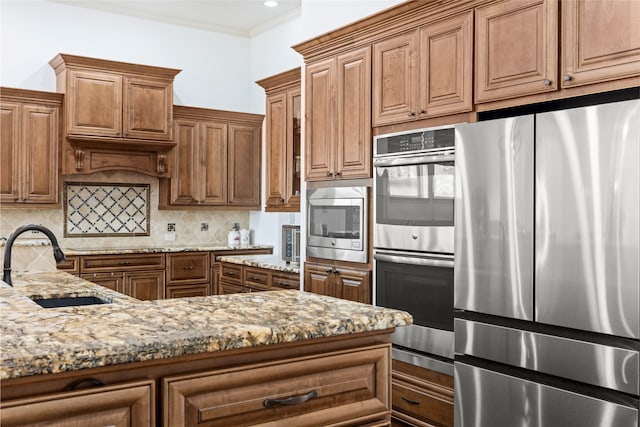 kitchen featuring tasteful backsplash, sink, ornamental molding, stainless steel appliances, and light stone countertops