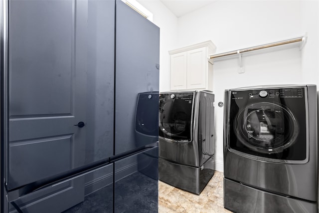 washroom with cabinets and washing machine and dryer