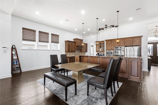 dining room featuring ornamental molding, dark hardwood / wood-style floors, and a towering ceiling