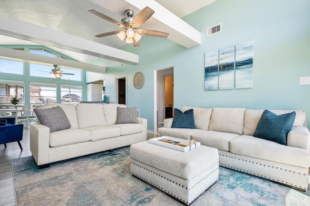 living room with hardwood / wood-style flooring, ceiling fan, and vaulted ceiling with beams