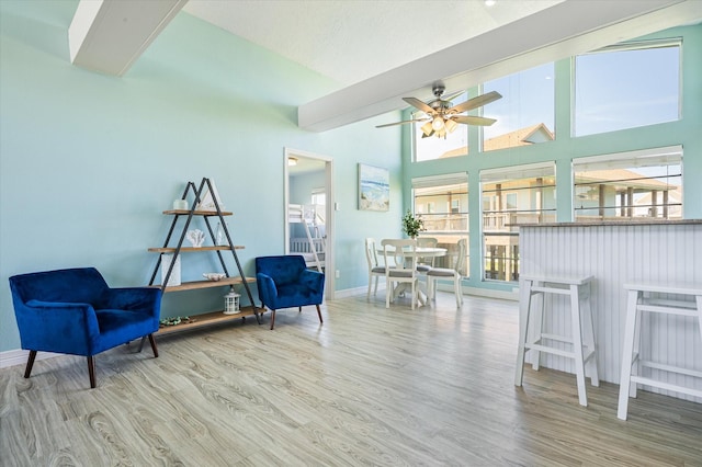 sitting room featuring high vaulted ceiling, hardwood / wood-style floors, and ceiling fan