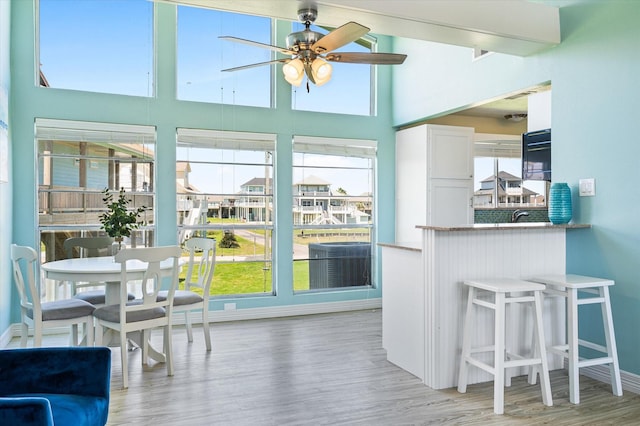 sunroom / solarium featuring ceiling fan