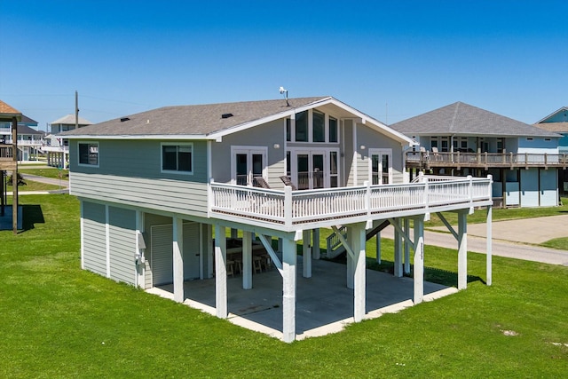 rear view of house featuring a patio, a yard, french doors, and a deck