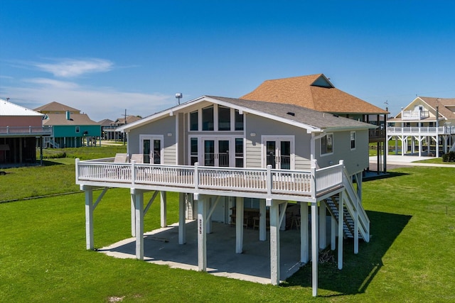 back of property featuring a wooden deck, a yard, a patio area, and french doors