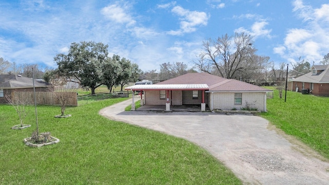 ranch-style home featuring a carport and a front lawn