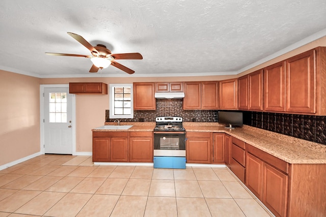 kitchen with stainless steel electric range oven, light tile patterned flooring, tasteful backsplash, sink, and light stone counters