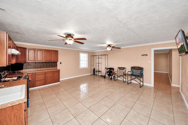 kitchen featuring light tile patterned floors, tasteful backsplash, ornamental molding, a textured ceiling, and gas range