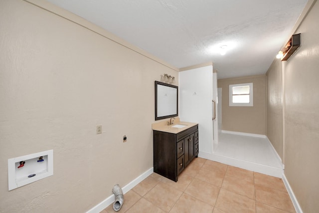 clothes washing area featuring hookup for a washing machine, electric dryer hookup, sink, and light tile patterned floors