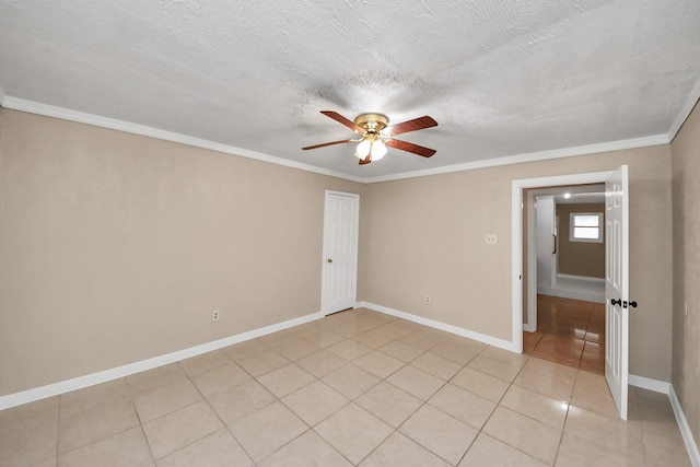 tiled spare room featuring ornamental molding, ceiling fan, and a textured ceiling