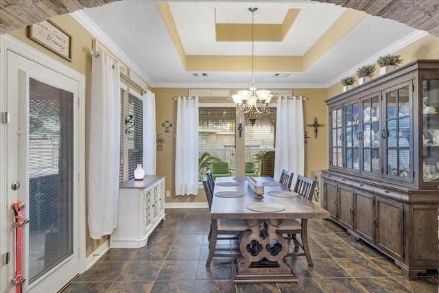 dining space featuring a notable chandelier, ornamental molding, and a raised ceiling