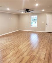 empty room featuring crown molding, light hardwood / wood-style flooring, and ceiling fan