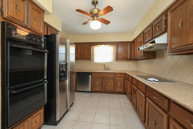 kitchen with sink, backsplash, light tile patterned floors, ceiling fan, and black appliances