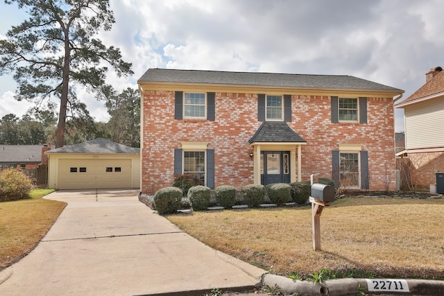 colonial inspired home with a garage, an outdoor structure, central AC unit, and a front yard