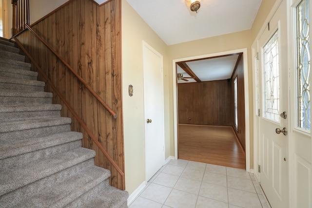 interior space featuring light tile patterned flooring and wood walls