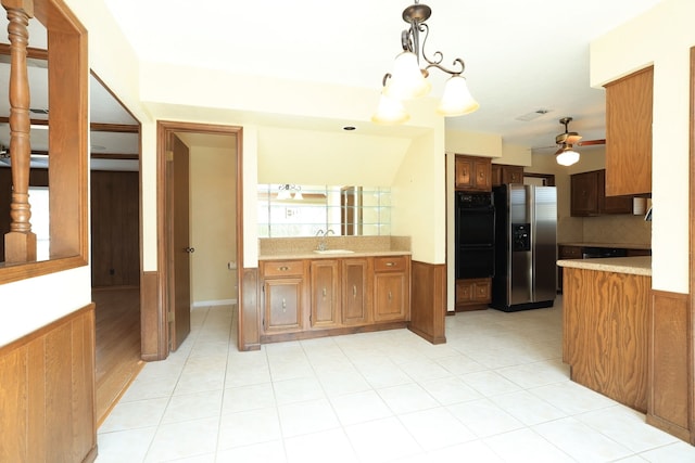 kitchen featuring sink, decorative light fixtures, stainless steel fridge, black double oven, and decorative backsplash