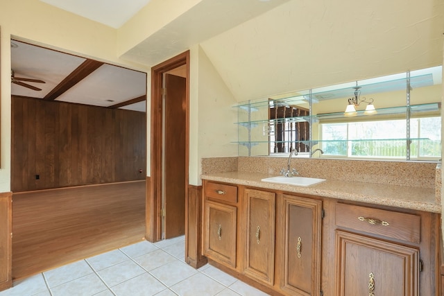 bathroom with ceiling fan, wooden walls, vanity, vaulted ceiling, and tile patterned floors