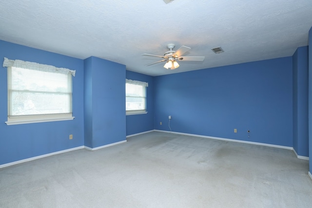 carpeted empty room with a textured ceiling and ceiling fan