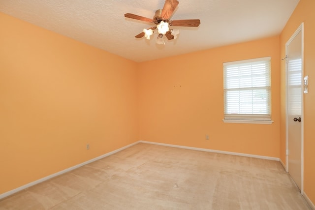 carpeted spare room with ceiling fan and a textured ceiling