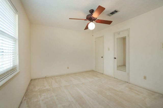 spare room with light colored carpet and ceiling fan