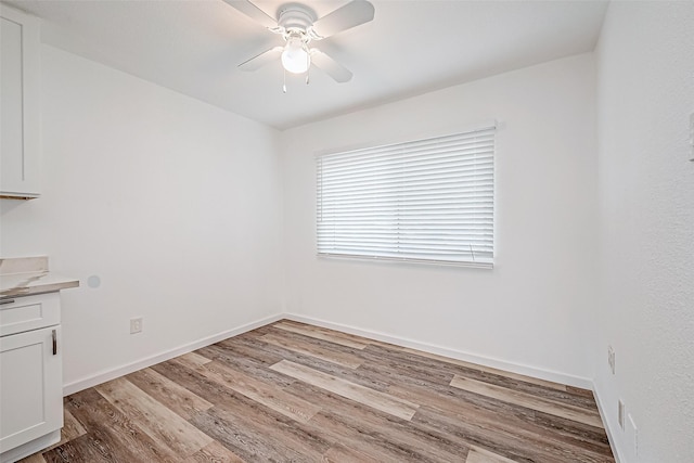 unfurnished dining area featuring ceiling fan and light hardwood / wood-style floors