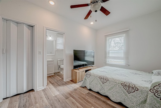 bedroom with ensuite bathroom, ceiling fan, and light wood-type flooring