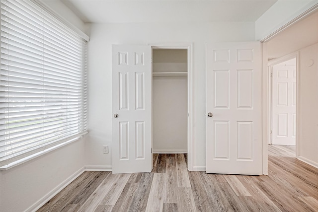 unfurnished bedroom featuring a closet and light wood-type flooring