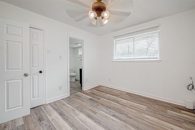 unfurnished bedroom featuring connected bathroom, ceiling fan, and light wood-type flooring