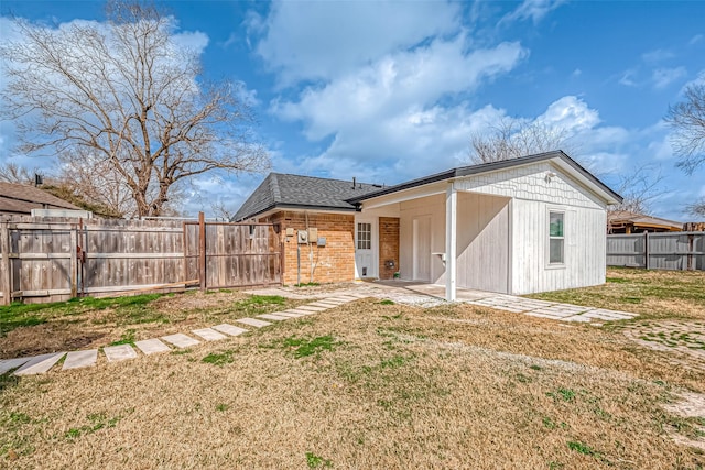 rear view of property featuring a lawn