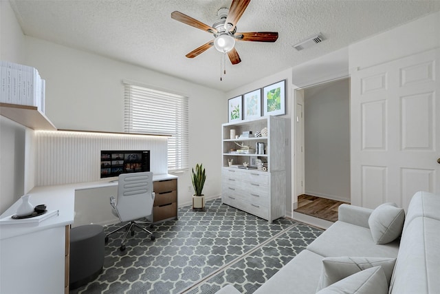 home office featuring ceiling fan and a textured ceiling