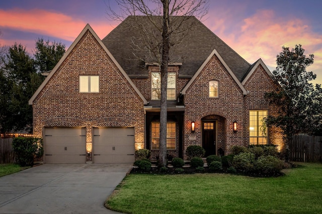 tudor-style house with a garage and a yard