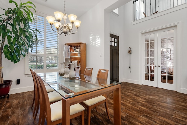 dining space featuring dark wood-type flooring, french doors, and a chandelier