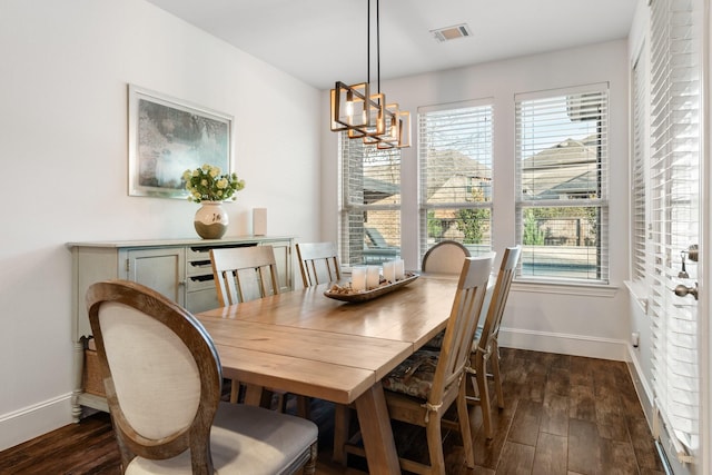 dining area featuring dark hardwood / wood-style flooring and a notable chandelier