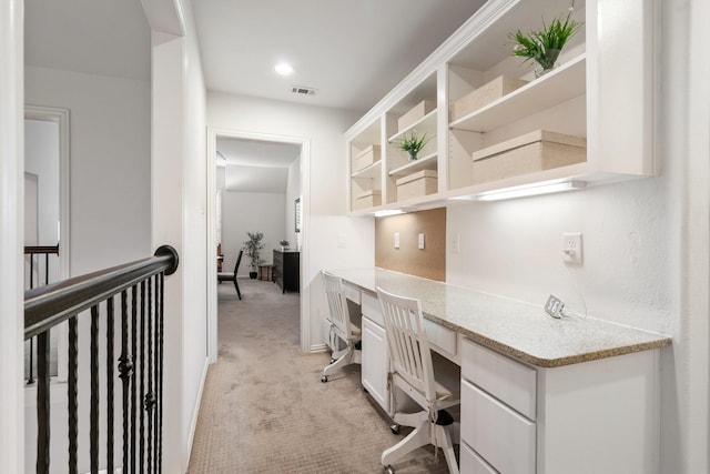 carpeted home office featuring built in desk