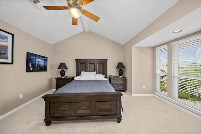 bedroom with light carpet, vaulted ceiling with beams, a textured ceiling, and ceiling fan