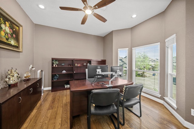 home office with ceiling fan and light hardwood / wood-style flooring