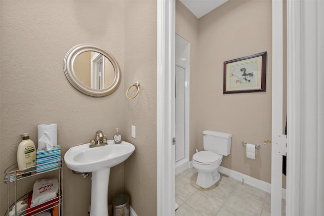 bathroom featuring sink, toilet, and tile patterned flooring