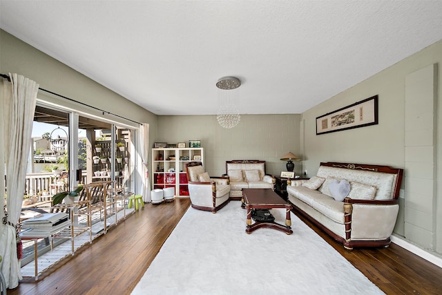 living room with dark hardwood / wood-style floors and a notable chandelier