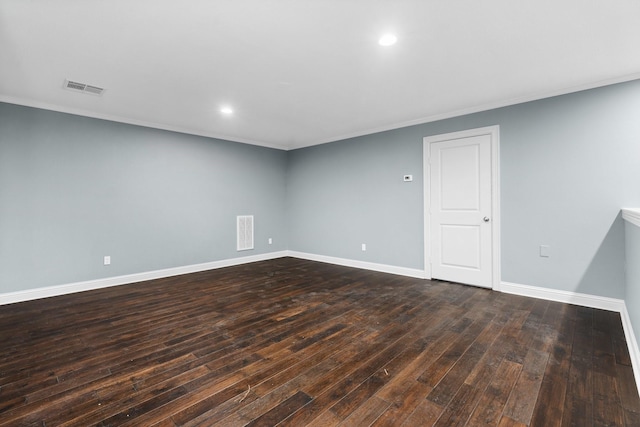 spare room featuring dark wood-type flooring and ornamental molding