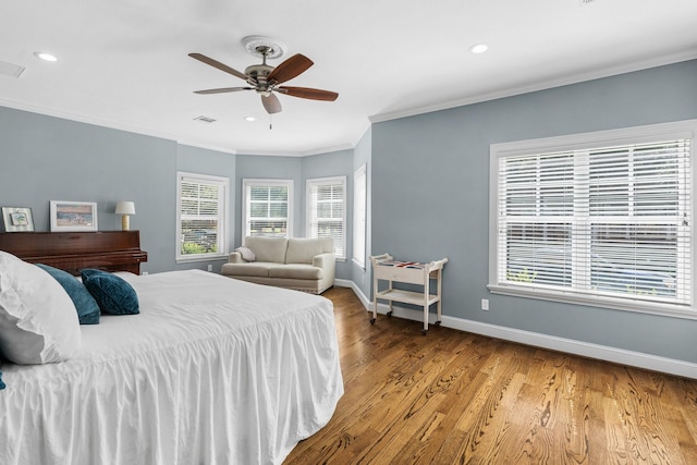 bedroom with multiple windows, ornamental molding, hardwood / wood-style flooring, and ceiling fan