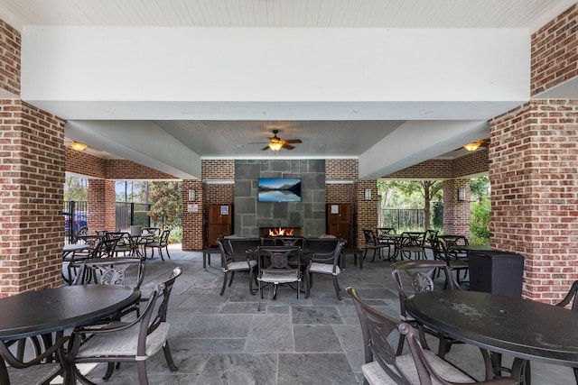 view of patio featuring ceiling fan and a fireplace