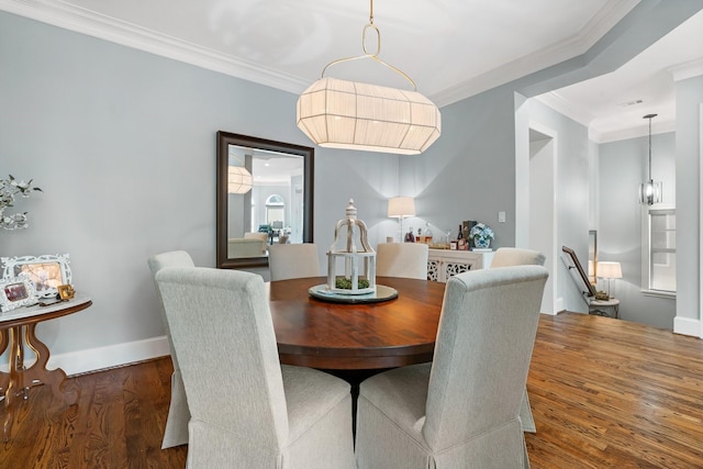 dining area with ornamental molding and dark hardwood / wood-style floors