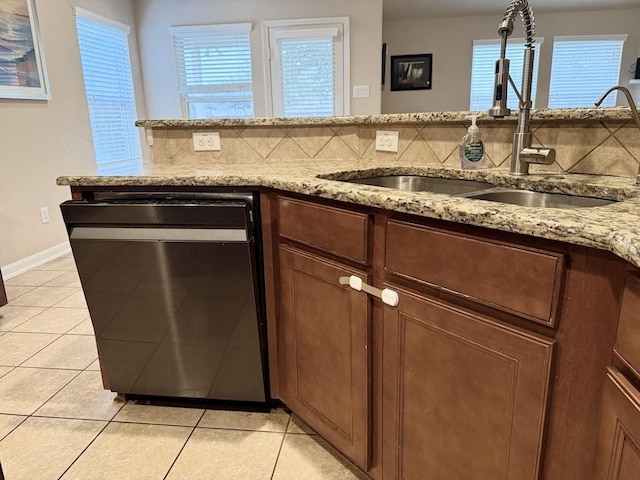 kitchen with a sink, decorative backsplash, dishwasher, and light tile patterned flooring